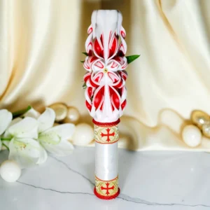 Lumânare ceremonială sculptată manual, albă cu roșu și auriu, fotografiată pe fundal elegant luminos, potrivită pentru ceremonii, Paște și Înviere