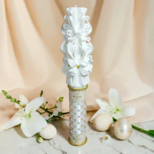 Lumânare ceremonială sculptată manual, albă cu auriu, fotografiată pe fundal elegant luminos, potrivită pentru ceremonii și Paște